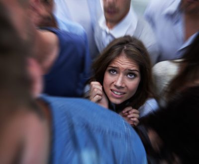 Drowning in people. Shot of a fearful young woman feeling trapped by the crowd